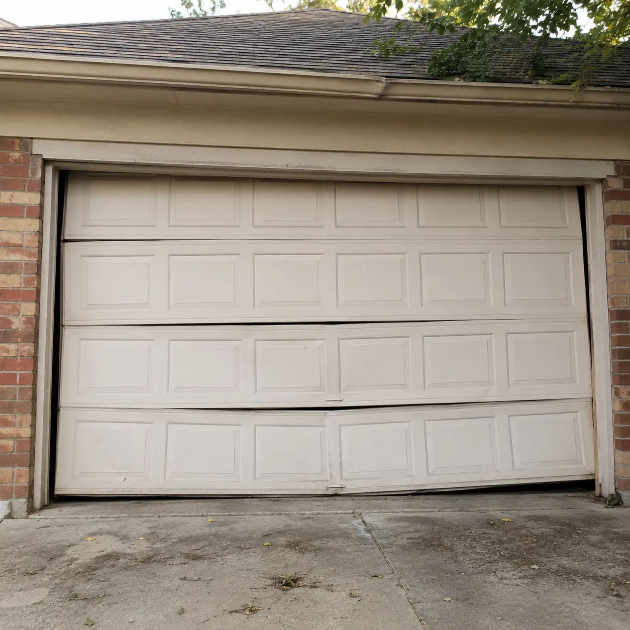 Residential garage door before professional repair in Lawrence