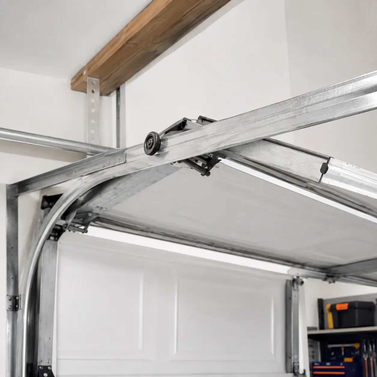 Lawrence Garage Door Pro technician lubricating rollers and tightening garage door hardware